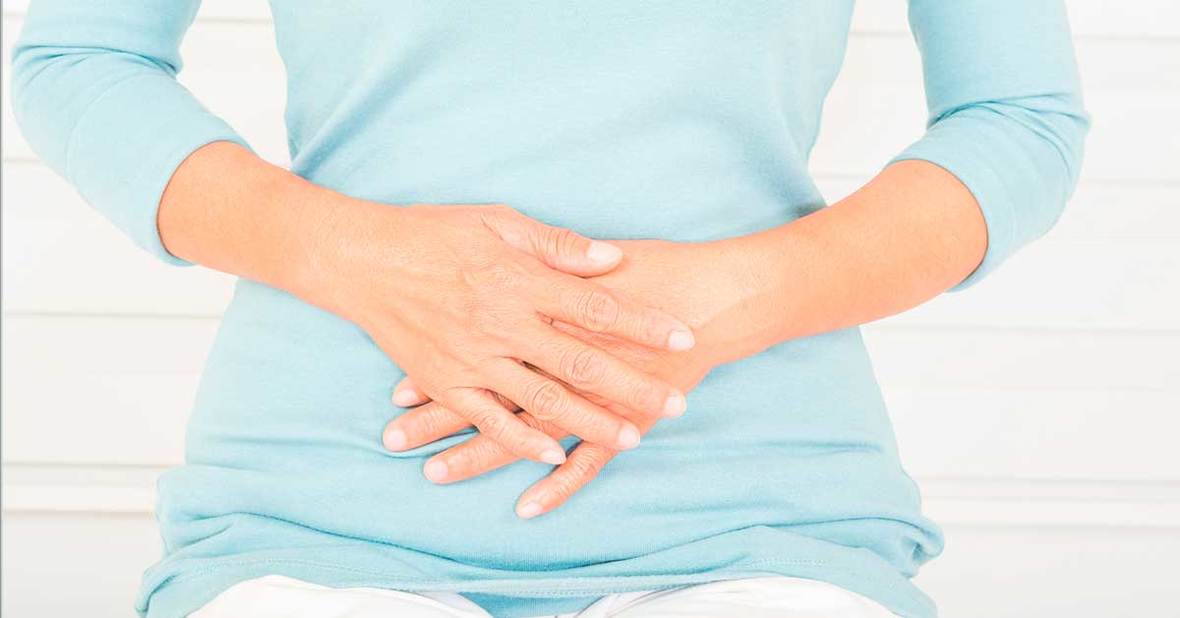 Persona con las manos encima de la barriga porque sufre de estreñimiento, un problema común en la tercera edad