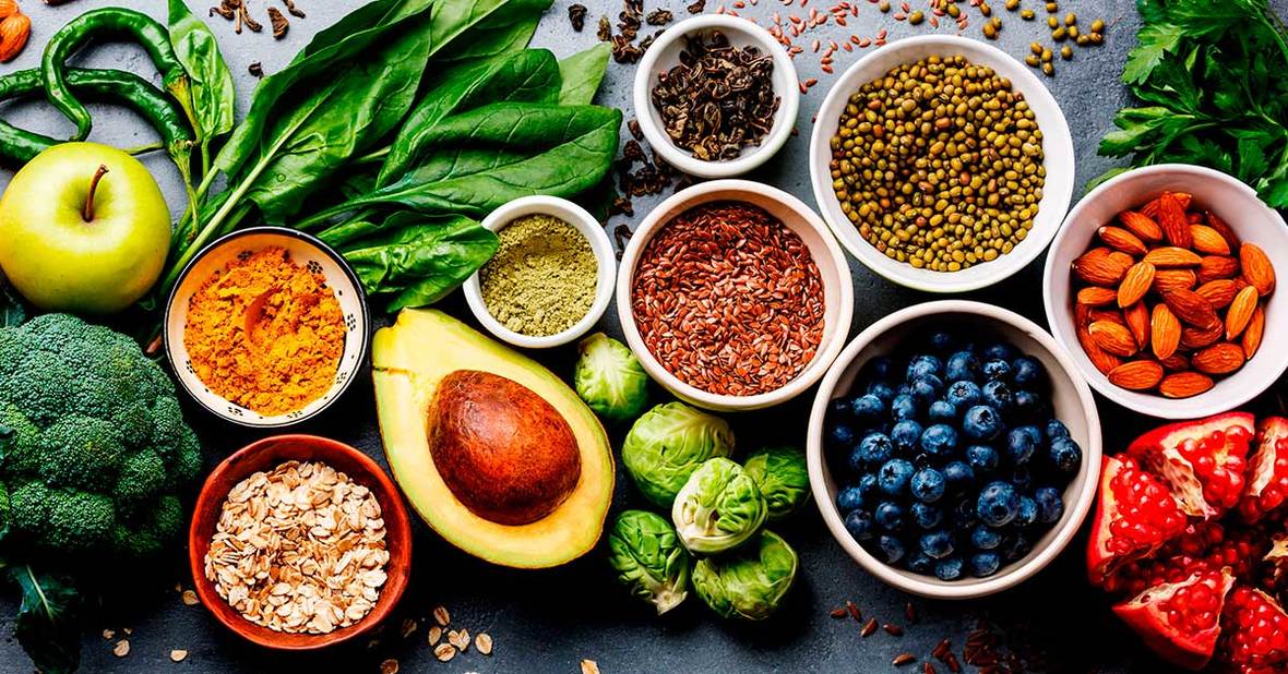 Mesa llena de alimentos saludables recomendables para personas con falta de apetito como frutas, verduras y frutos secos