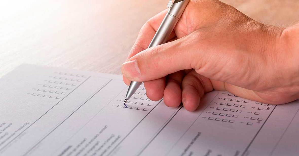 Mano de una persona rellenando papeles para solicitar ayudas para la dependencia