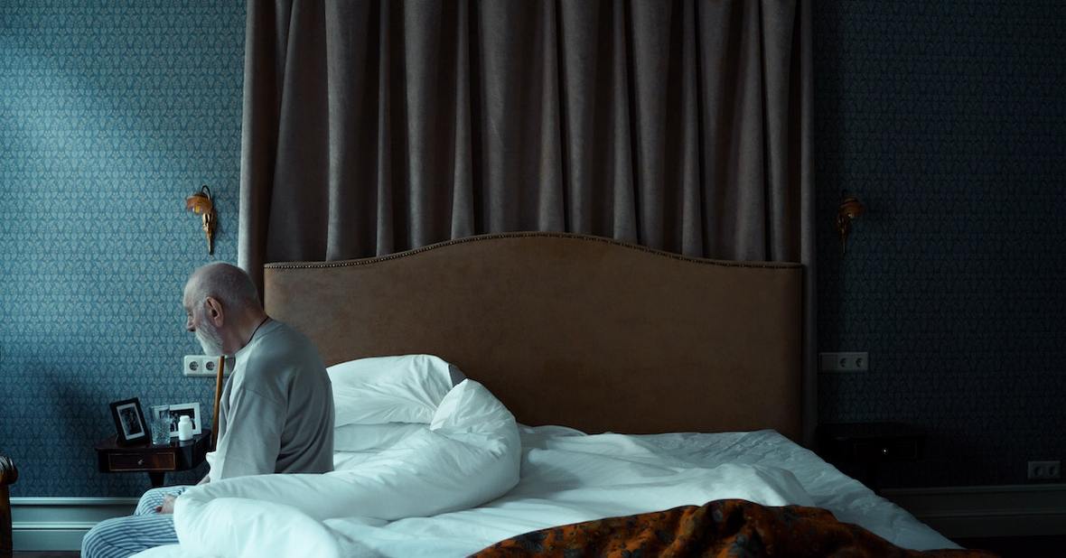 hombre sentado en la cama solo