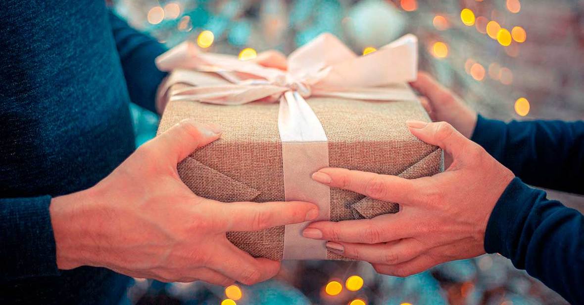 Persona entregando un regalo perfectamente envuelto a un hombre mayor