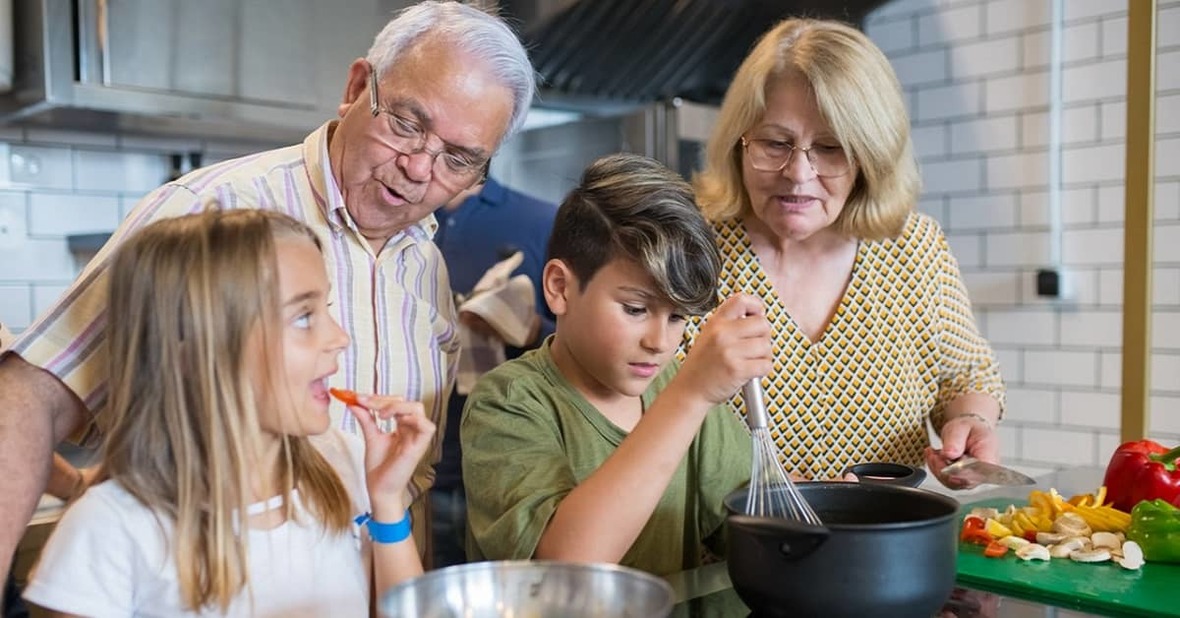 Abuelos cocinando con sus dos nietos