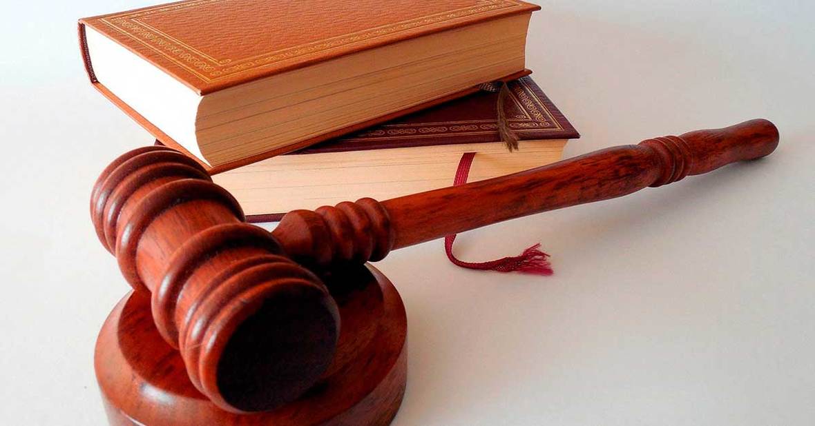 Imagen de unas libros de derecho y un mazo de juez, la persona encargada de nombrar a alguien tutor legal de una persona mayor