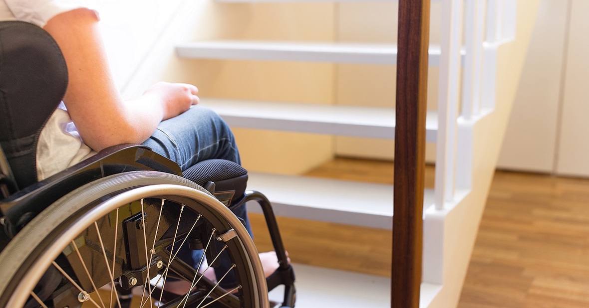 Persona en silla de ruedas intentando subir una escalera