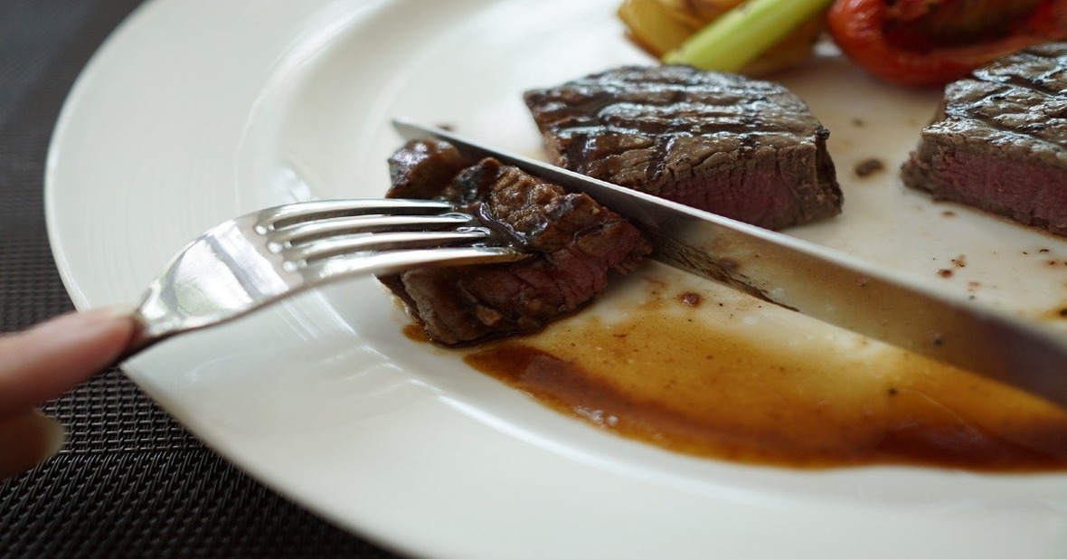 Persona cortando filete de carne para prevenir el atragantamiento