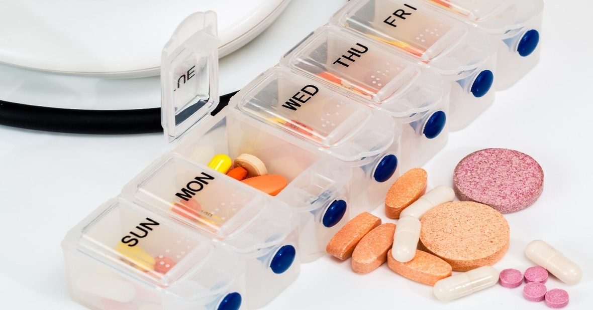Pastillero con medicación de una persona mayor con riesgo a una interacción entre medicamentos y alimentación