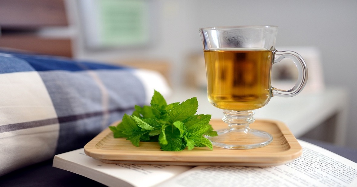 Taza de té sobre una bandeja en la mesilla del dormitorio para calmar por la noche al mayor que sufre de agitación nocturna