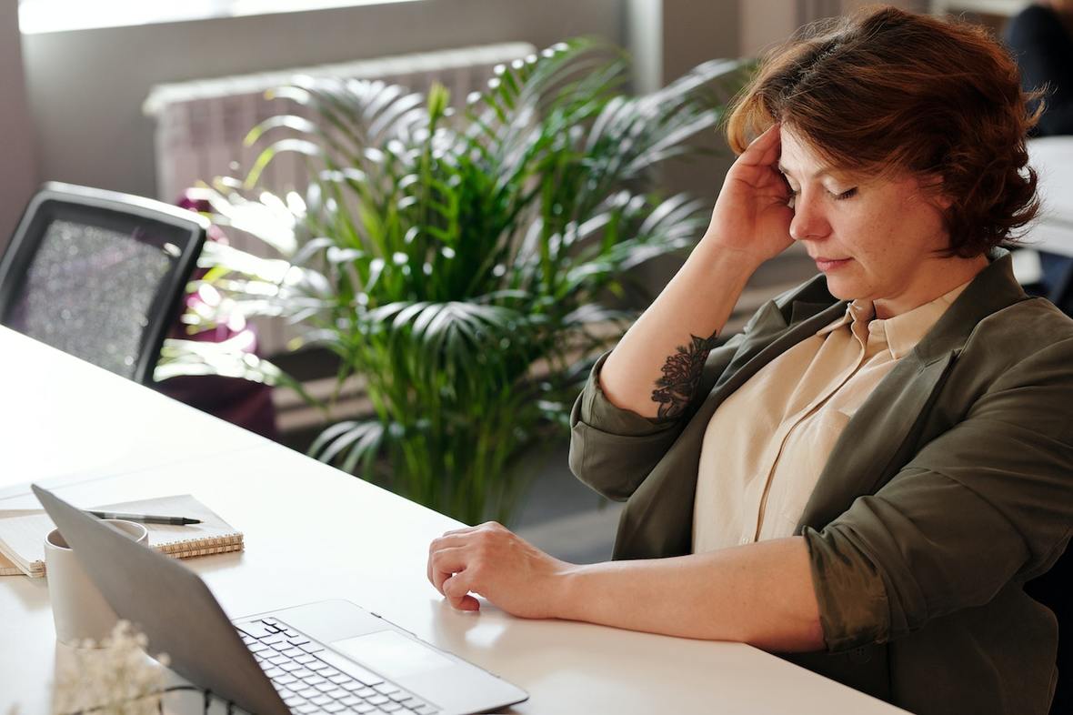 Mujer tocándose la cabeza expresando malestar