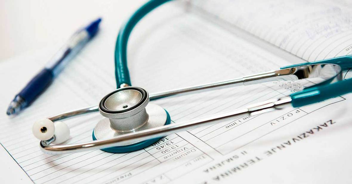 Estetoscopio sobre papeles médicos de un paciente con alzhéimer