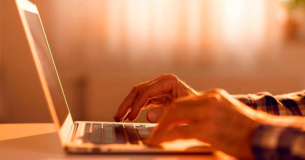 Adulto mayor utilizando un ordenador, un dispositivo tecnológico con el que las personas mayores suelen necesitar ayuda